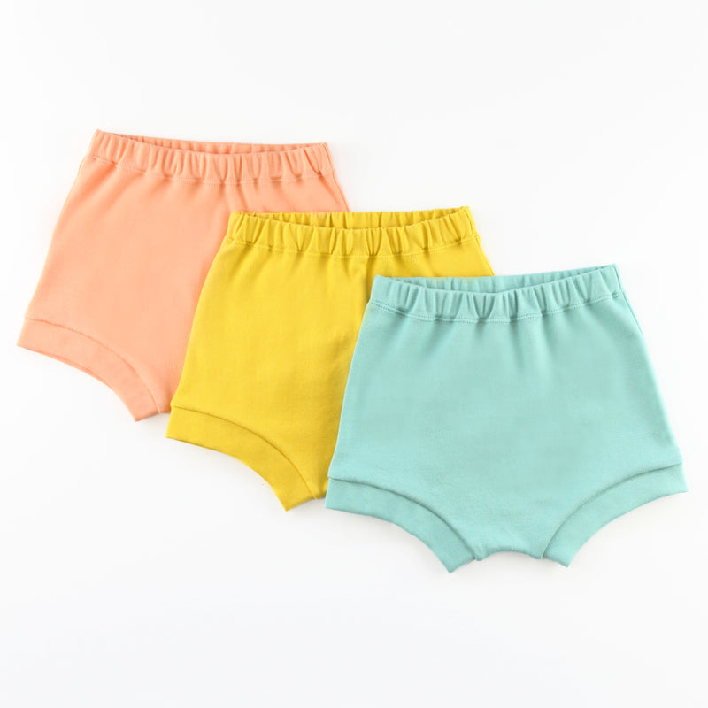 three baby bummie shorts in peach, mustard yellow and teal