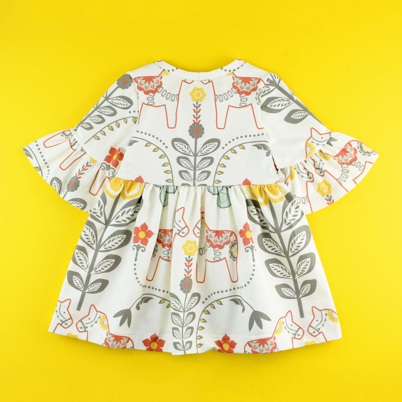 back of Bell Sleeve knit dress in floral dala horse fabric on yellow background