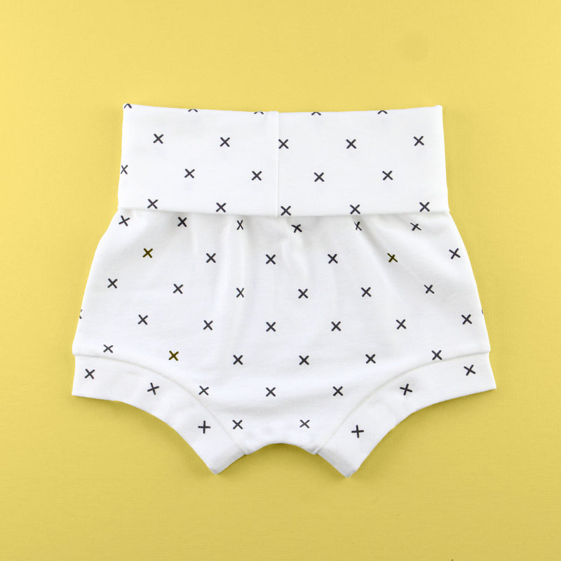 back of Fold over baby bummie shorts in an x fabric on a yellow background