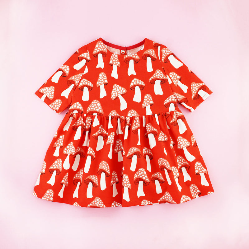 Red Mushroom Print Three Quarter Sleeve Toddler Dress on a Pink Background
